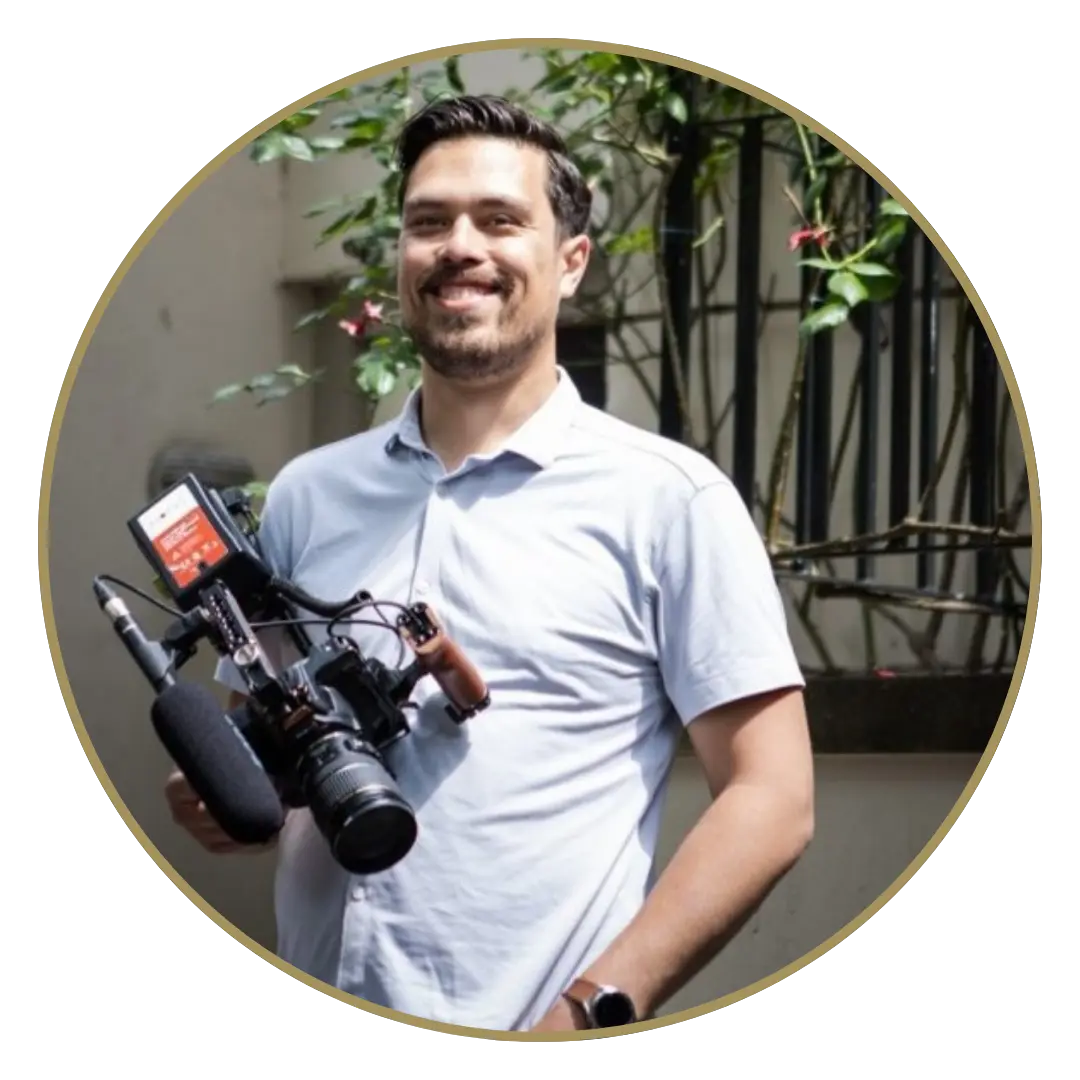 Een foto van Dejan Markx, hij lacht naar de camera hij heeft een grote videocamera in zijn hand.